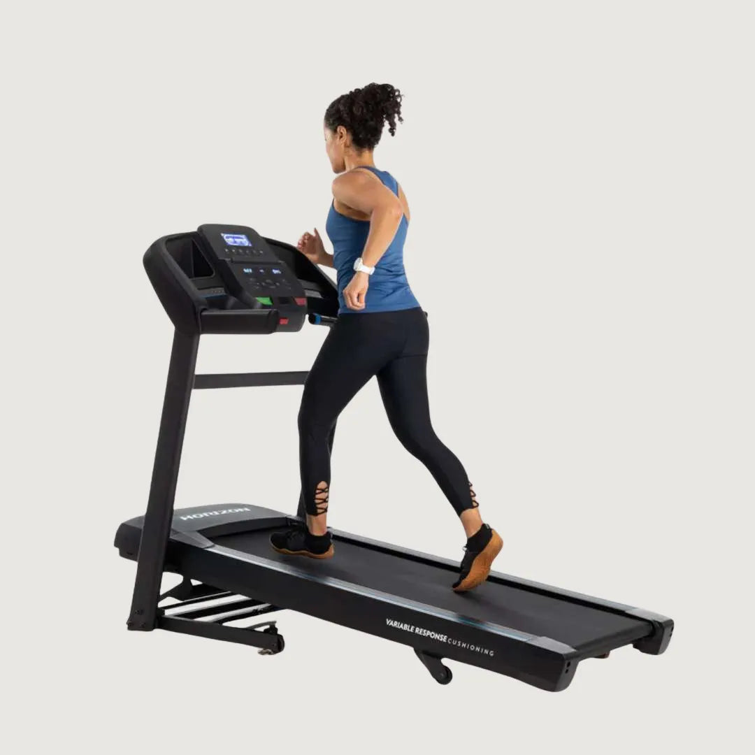 Woman walking on a Horizon treadmill with adjustable incline and digital controls.