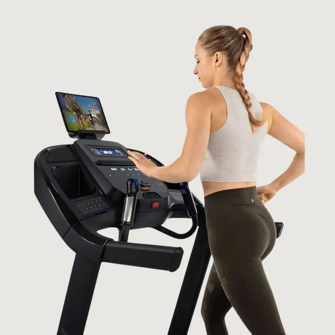 Woman running on Horizon treadmill with tablet on screen holder