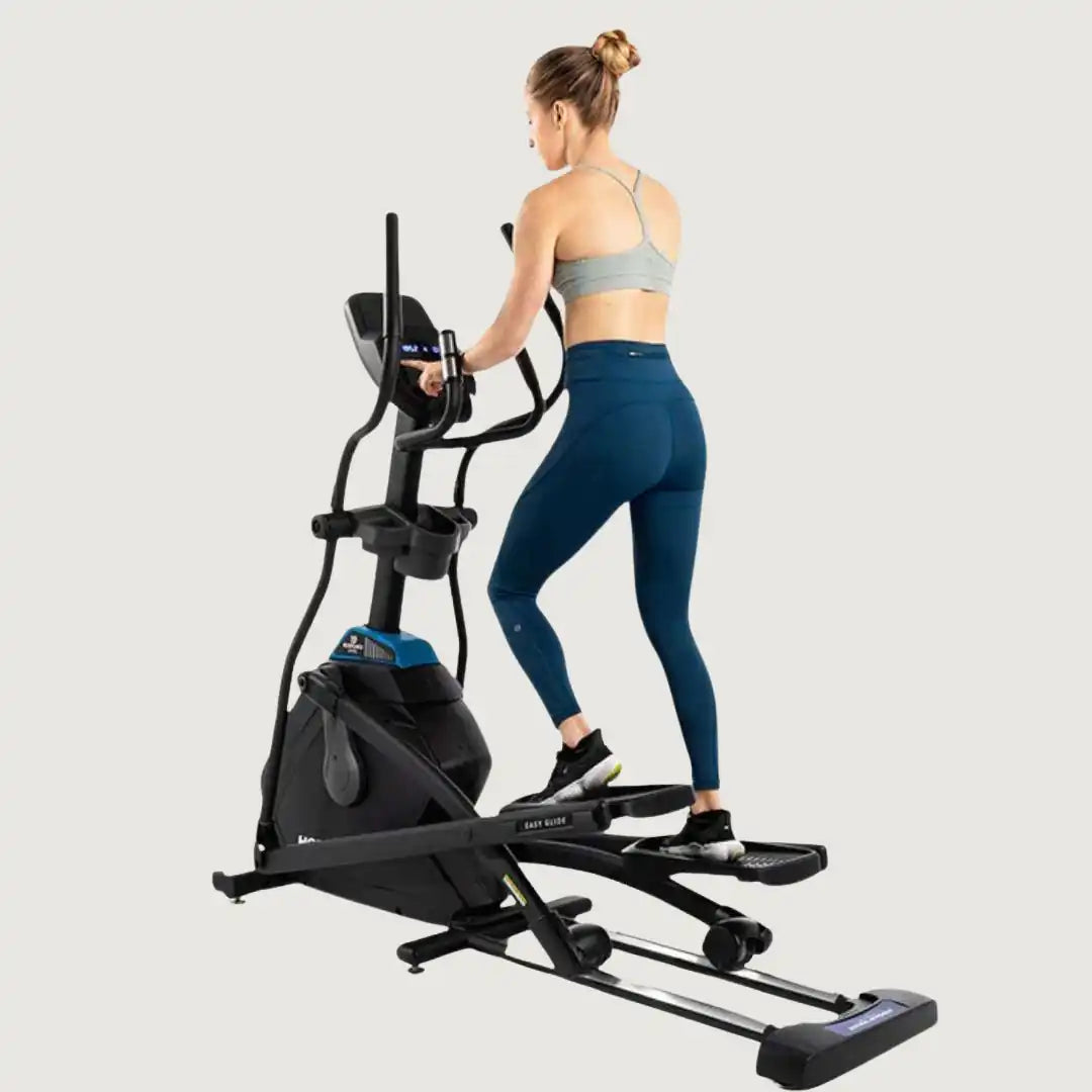 Rear view of woman using Horizon elliptical trainer for cardio exercise
