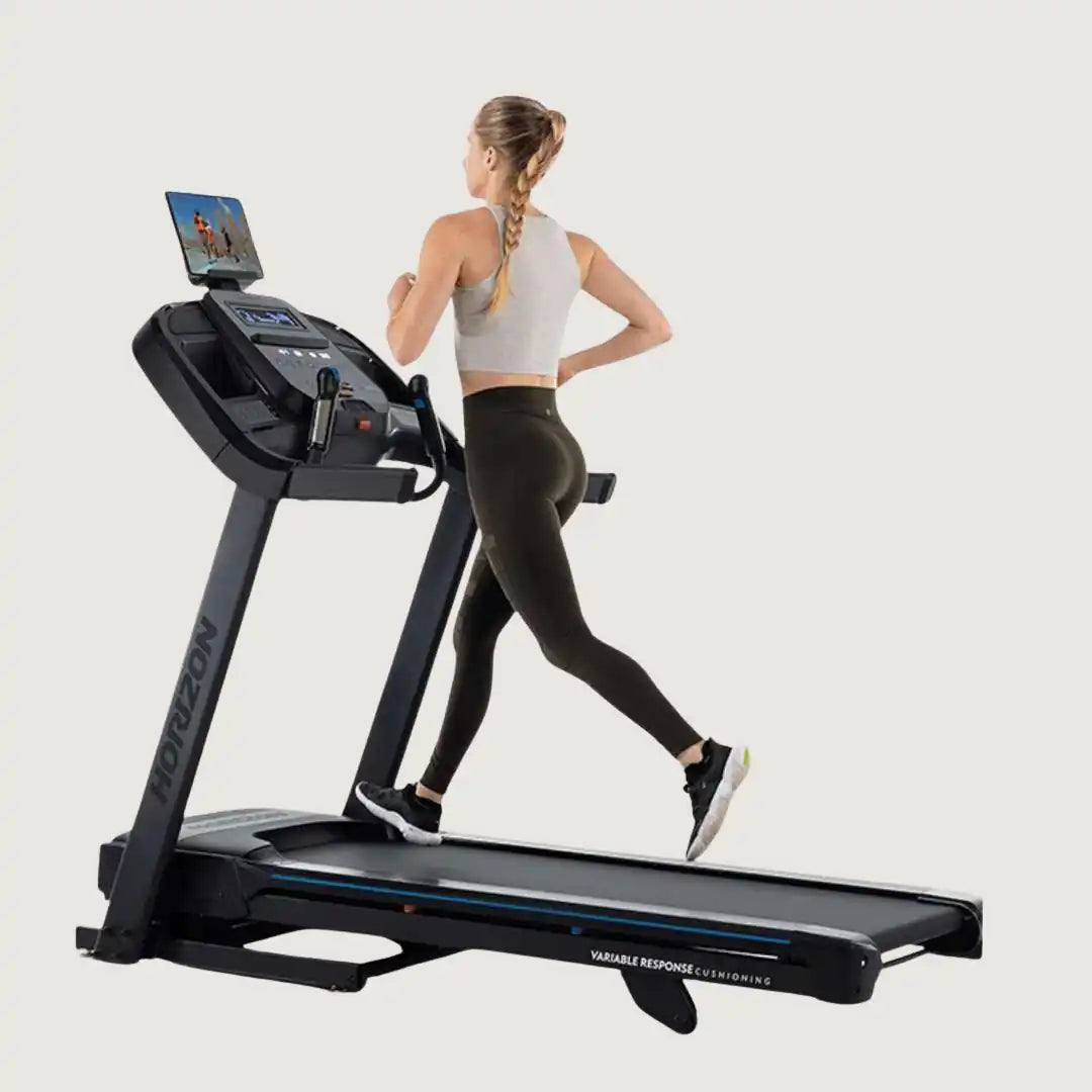 Woman adjusting the Horizon treadmill console while walking