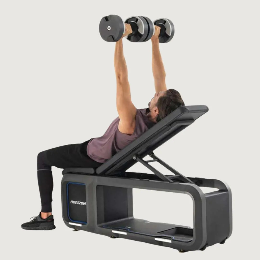 Man doing an incline dumbbell press while lying on the Horizon adjustable bench.
