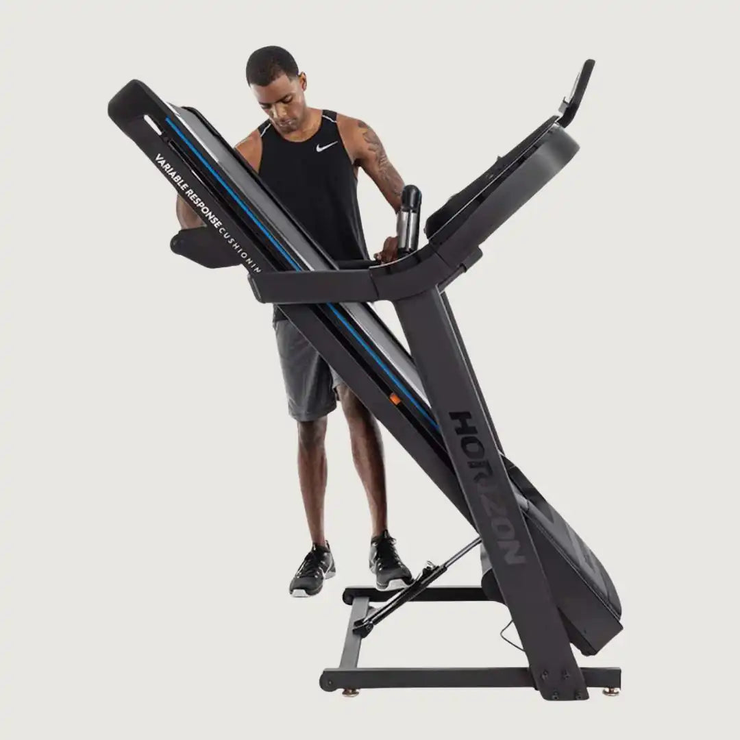 Man folding the Horizon treadmill vertically for storage