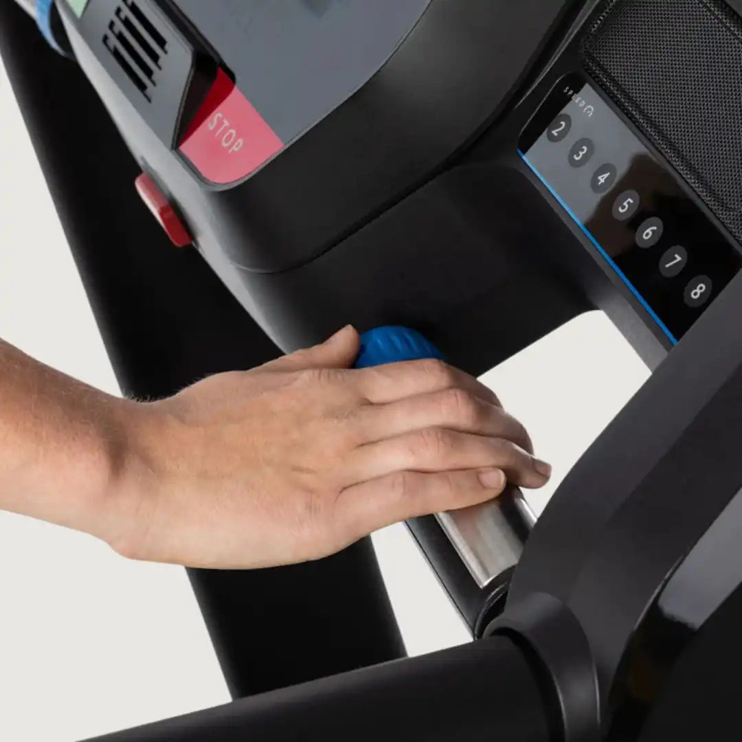 Close-up of hand adjusting incline or resistance knob on Horizon