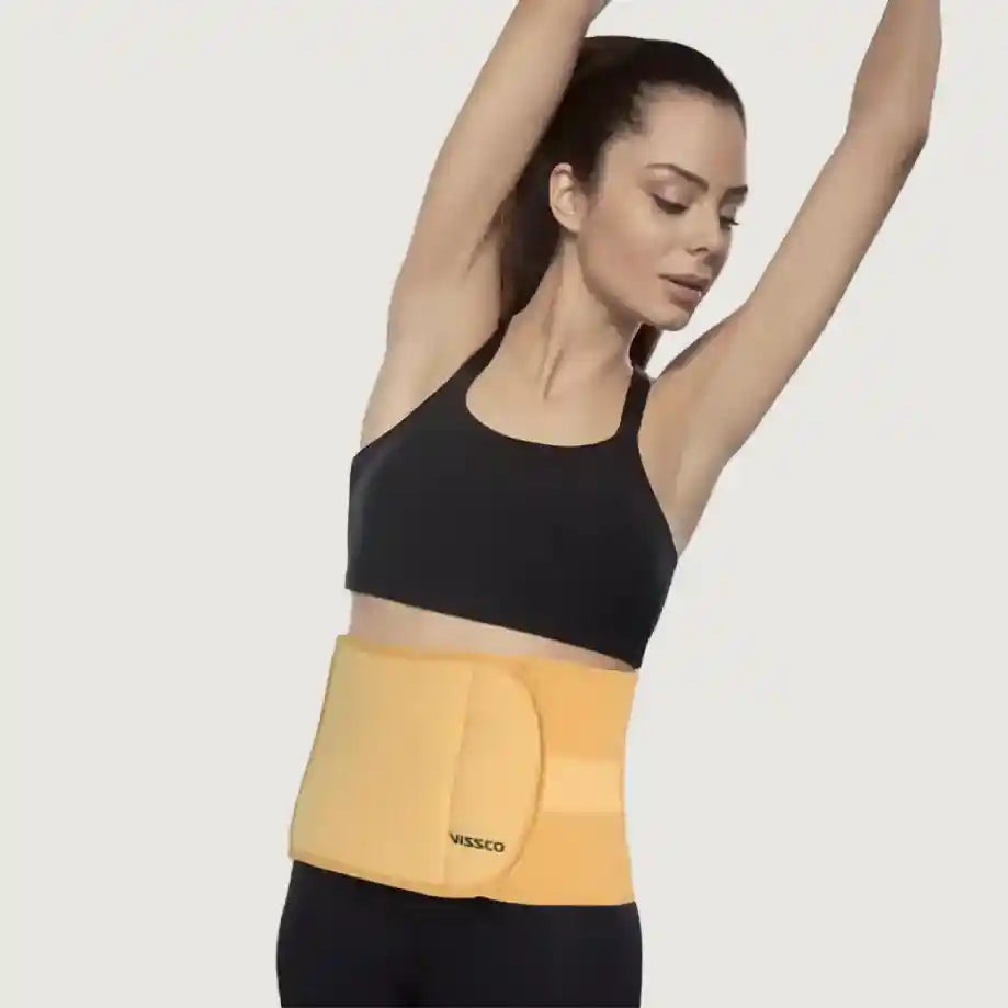 Woman wearing a yellow waist trainer with a plain background