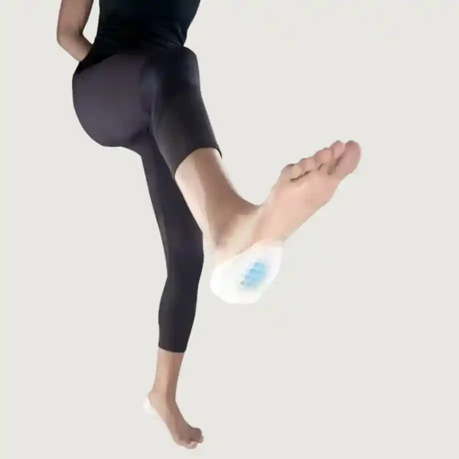 Person wearing black leggings with a white device on their foot against a light gray background