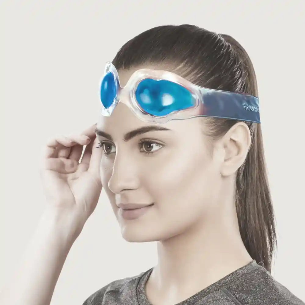 Woman wearing blue swim goggles on a plain background