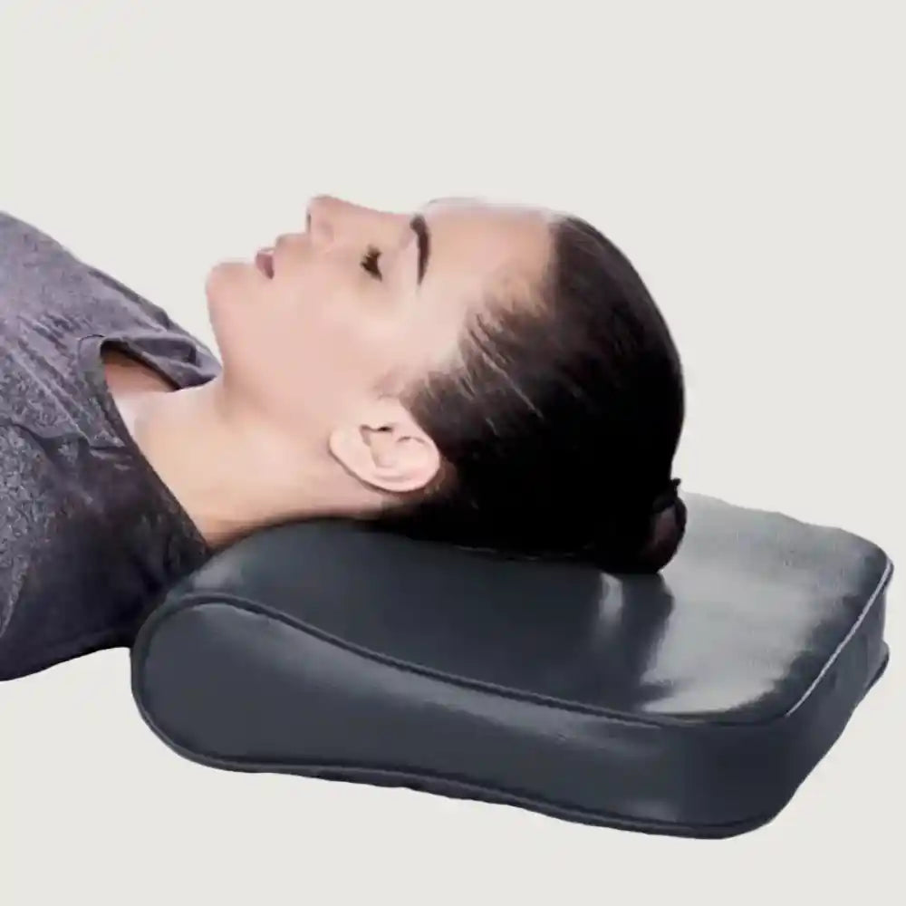 Person lying down with a black neck pillow on a plain background
