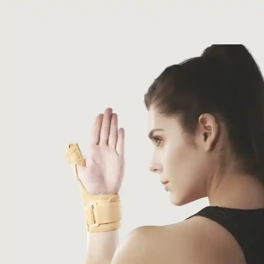 Woman wearing a beige wrist support on a plain background