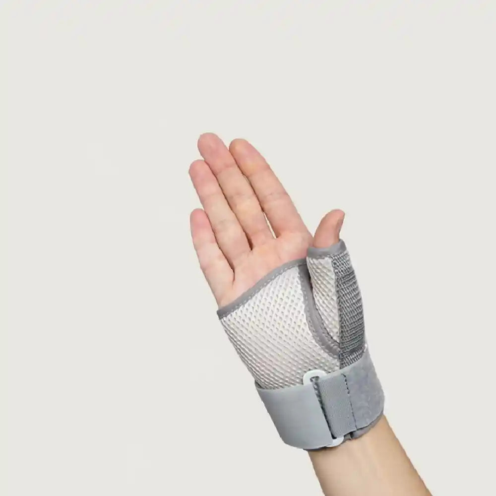 A gray and white mesh finger splint worn on a person's hand, shown against a plain light gray background.