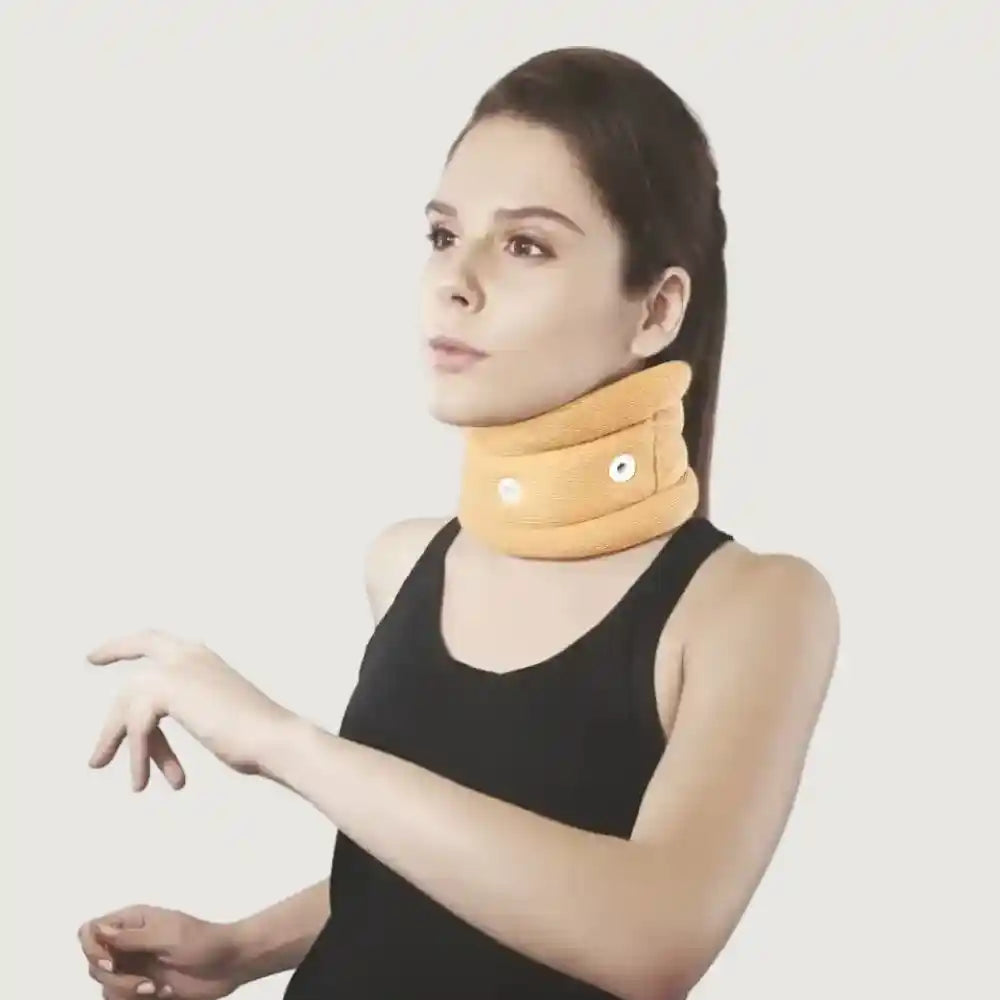 Woman wearing a yellow neck brace against a plain background