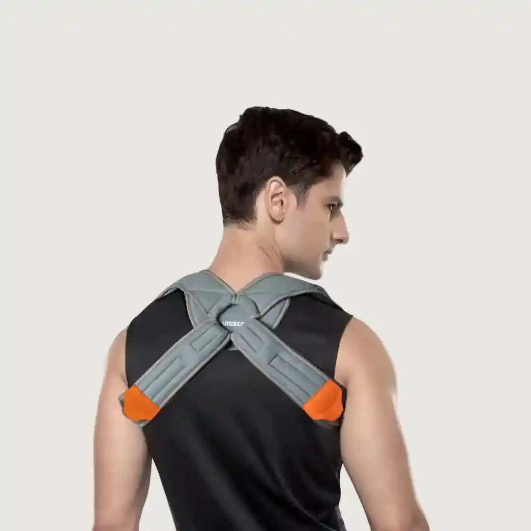 Person wearing a gray and orange posture corrector on a plain background
