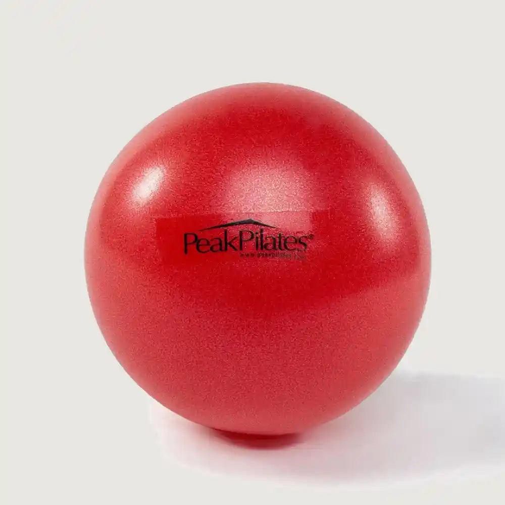 Red exercise ball with Peak Pilates logo on a white background