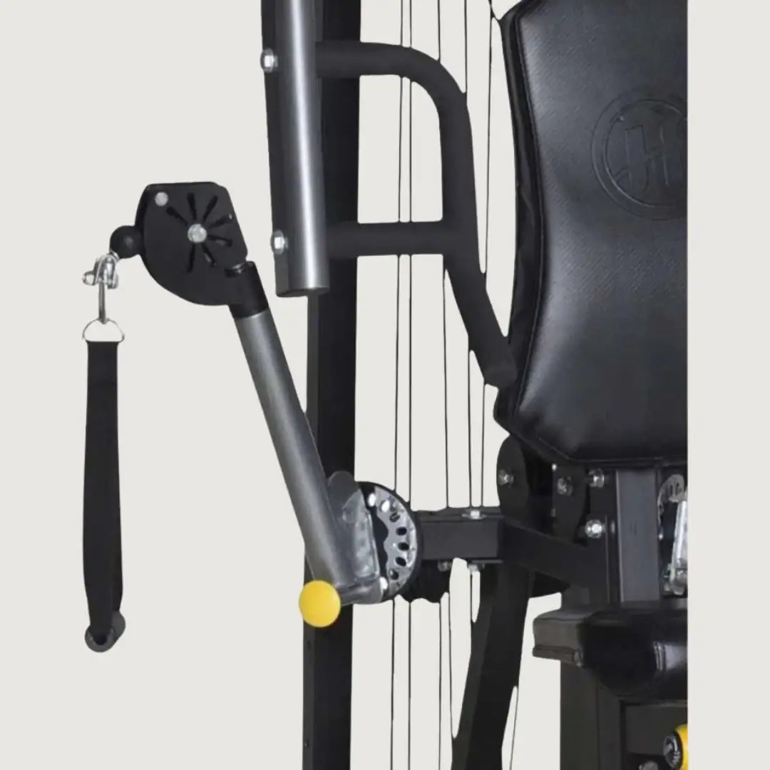 Close-up of the pulley and arm mechanism on the multi-gym showing the cable system in detail.
